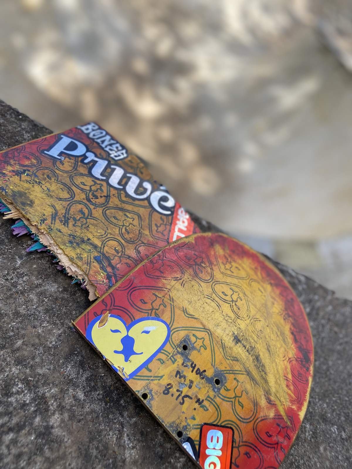 Shape de skate usado, com a pintura desgastada, apoiado no coping do bowl